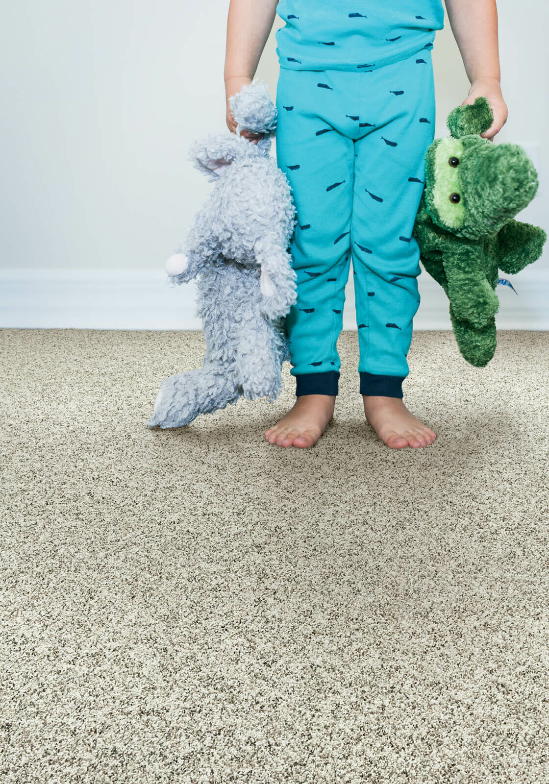 Kid with toys standing on soft carpet | Raider Flooring