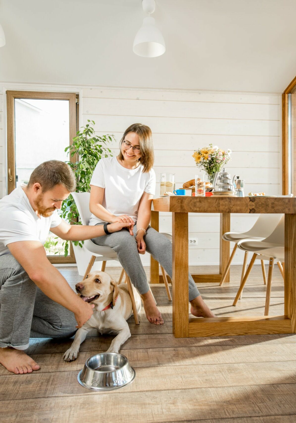 Happy couple with dog at home | Raider Flooring